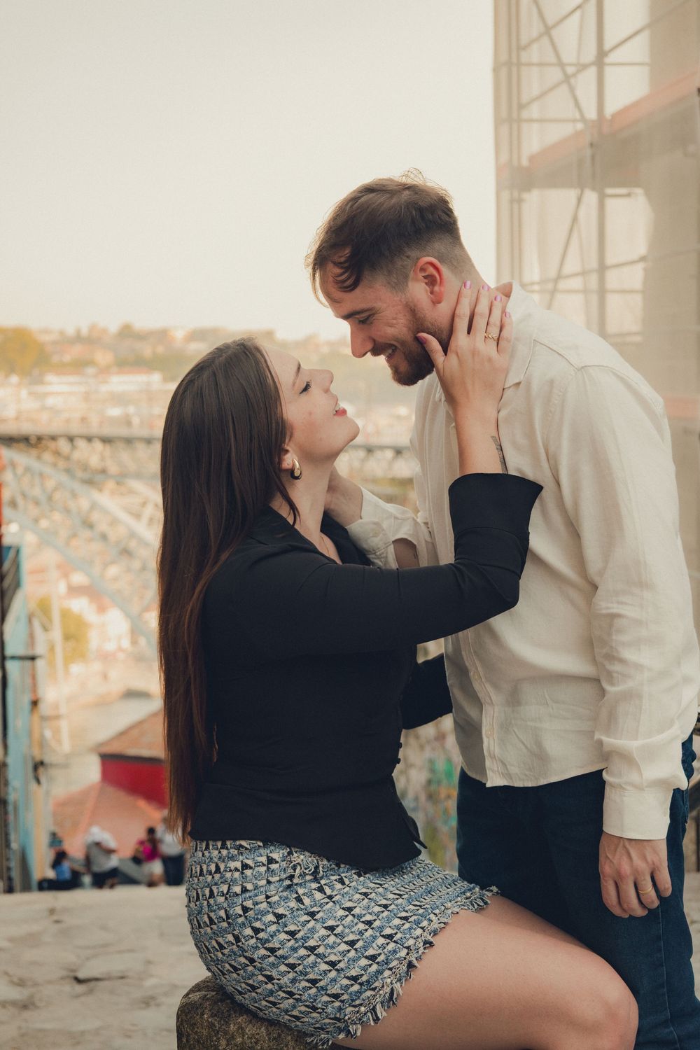 Intimate couple moment against urban backdrop during golden hour.