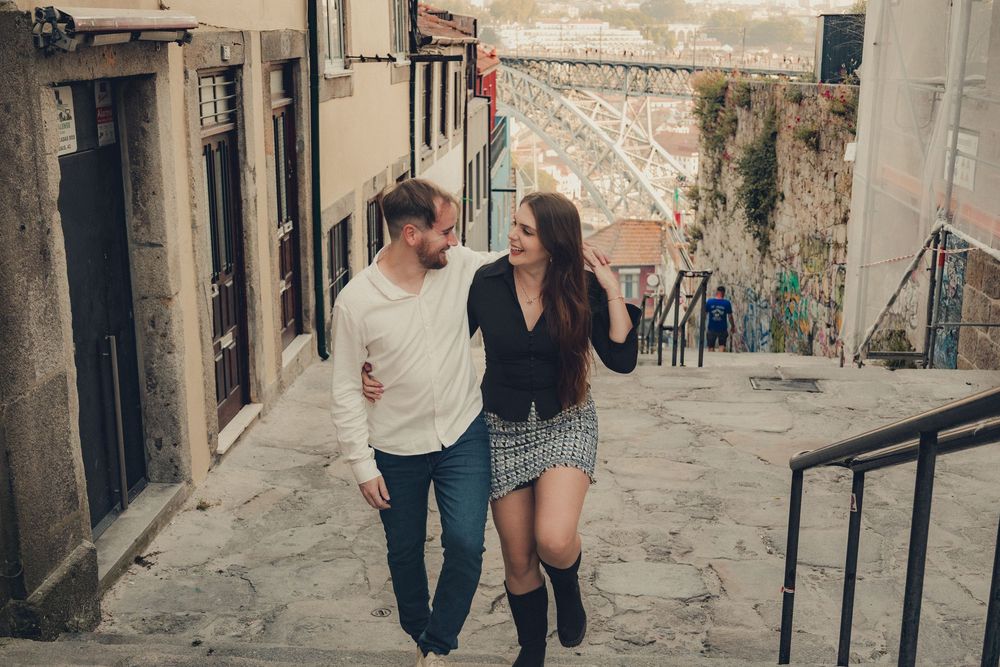Couple walking through historic cobblestone street.