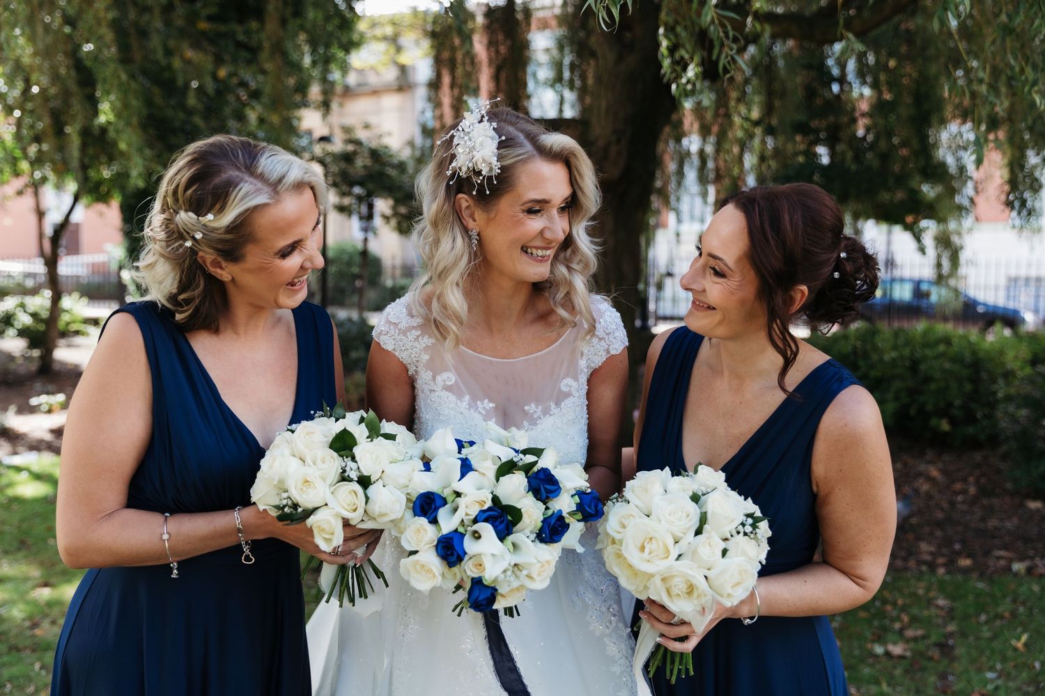 Wedding party in navy blue dresses poses together outdoors with white floral bouquets. Photographer. Hull. East Yorkshire. Photography