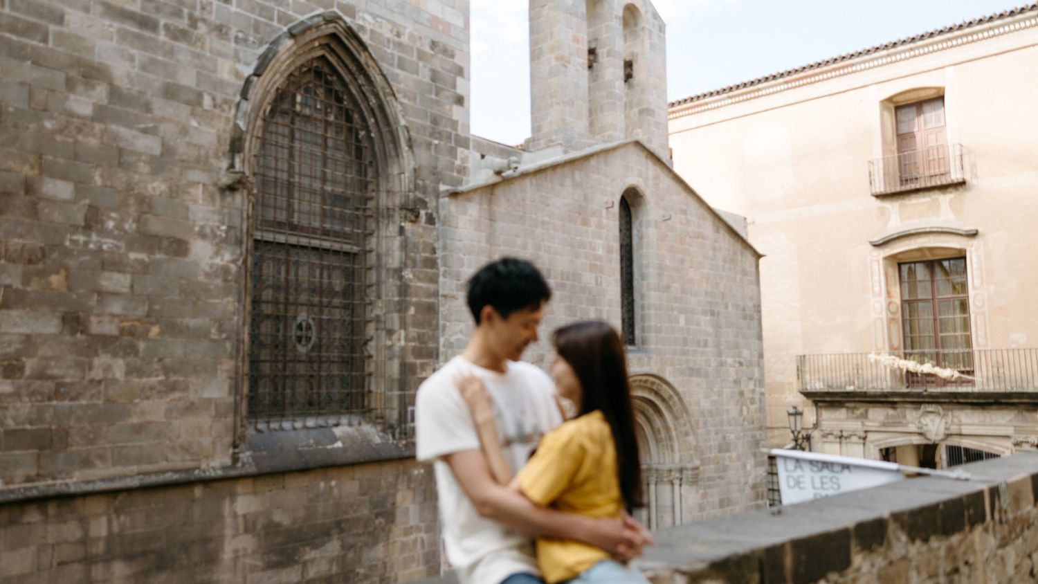Historic stone archways and medieval architecture along a narrow street in Barcelona's Gothic Quarter.