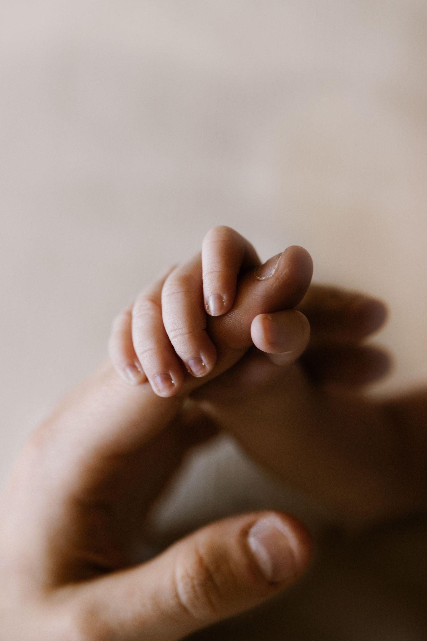 A tender black and white portrait of a caregiver and baby sharing an intimate moment in a nurturing embrace.