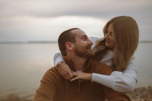 Couple shares joyful moments together near the ocean.