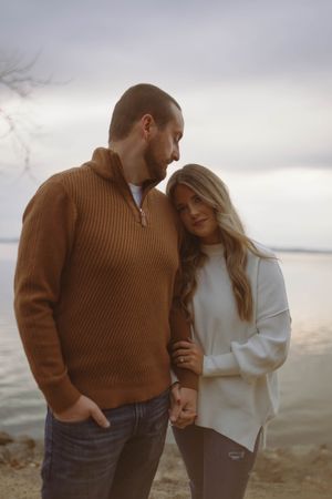 Couple shares intimate moment while standing near the water.