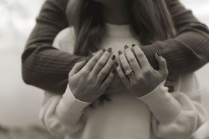 Artistic black and white close-up of hands touching tenderly.