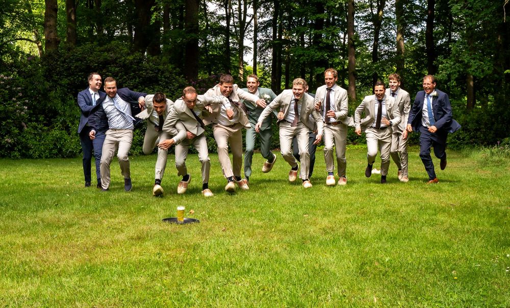 twaalf mannen in pak en klompen racen over het gras – de inzet: één glas bier op een dienblad."