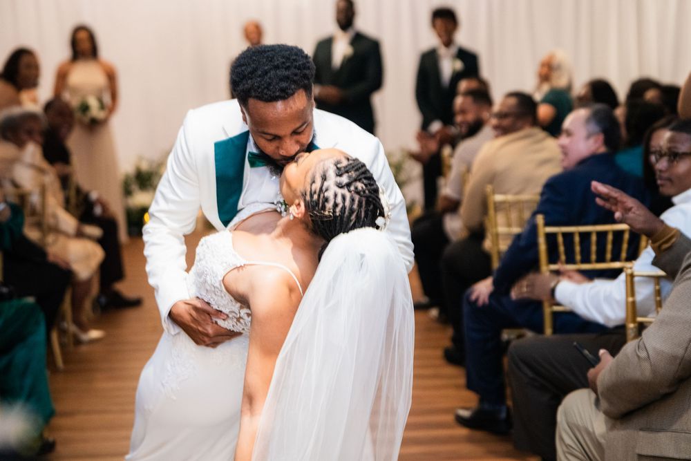 Two people share a captivating dance at their wedding reception as guests look on from their seats.