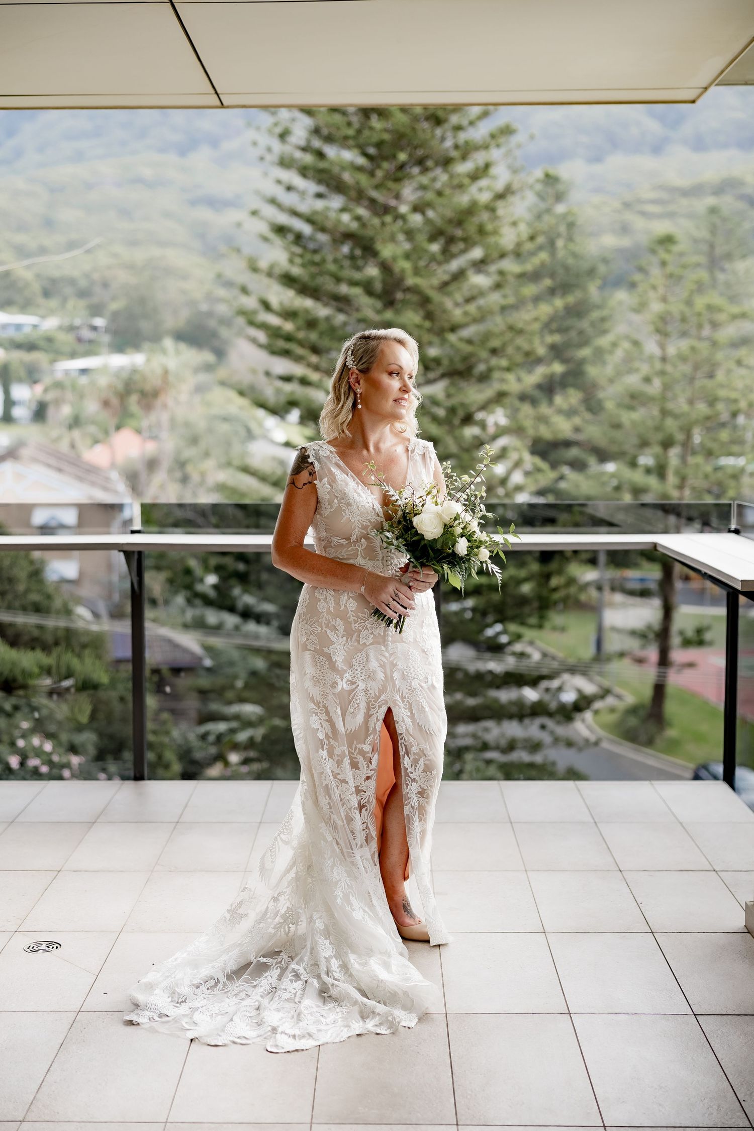Elegant bridal portrait session on a mountain balcony with scenic views and white lace wedding dress.