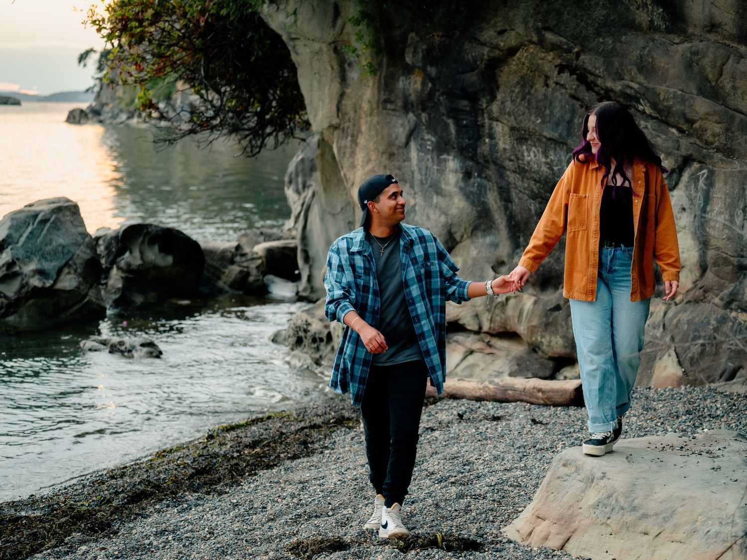 People in denim clothing walking along rocky coastal path with stone cliffs and water visible in series of shots.
