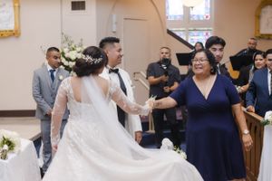 Wedding party members in navy blue dresses and formal attire gathered in church.