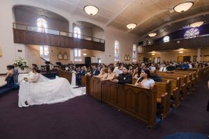 Wide angle view of church interior filled with wedding guests in pews.