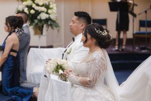 Elegant church wedding ceremony with white floral decorations and traditional setting.