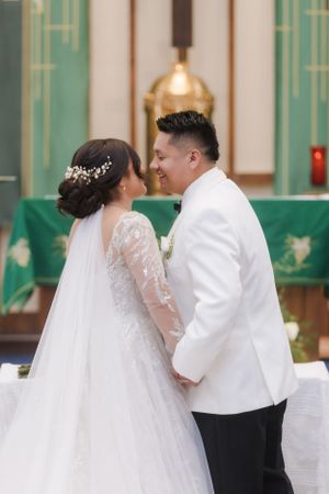 An intimate moment between newlyweds at the altar during their church ceremony.