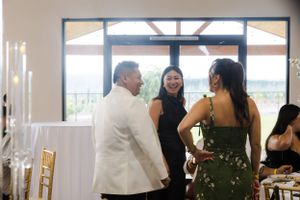 Elegant indoor wedding reception venue with white decor and natural lighting.