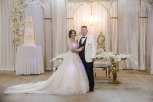 Elegant ballroom decorated with white floral arrangements and classic architectural details.