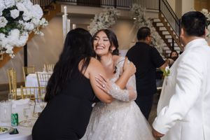 Wedding celebration with guests sharing joyful moments in an indoor venue.