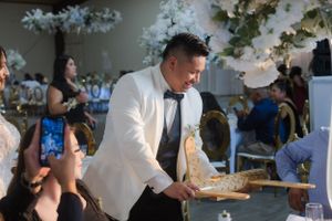 Wedding reception venue decorated with hanging lights and floral arrangements.