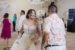 Wedding celebration with guests and decorative floral arrangements in an elegant venue.