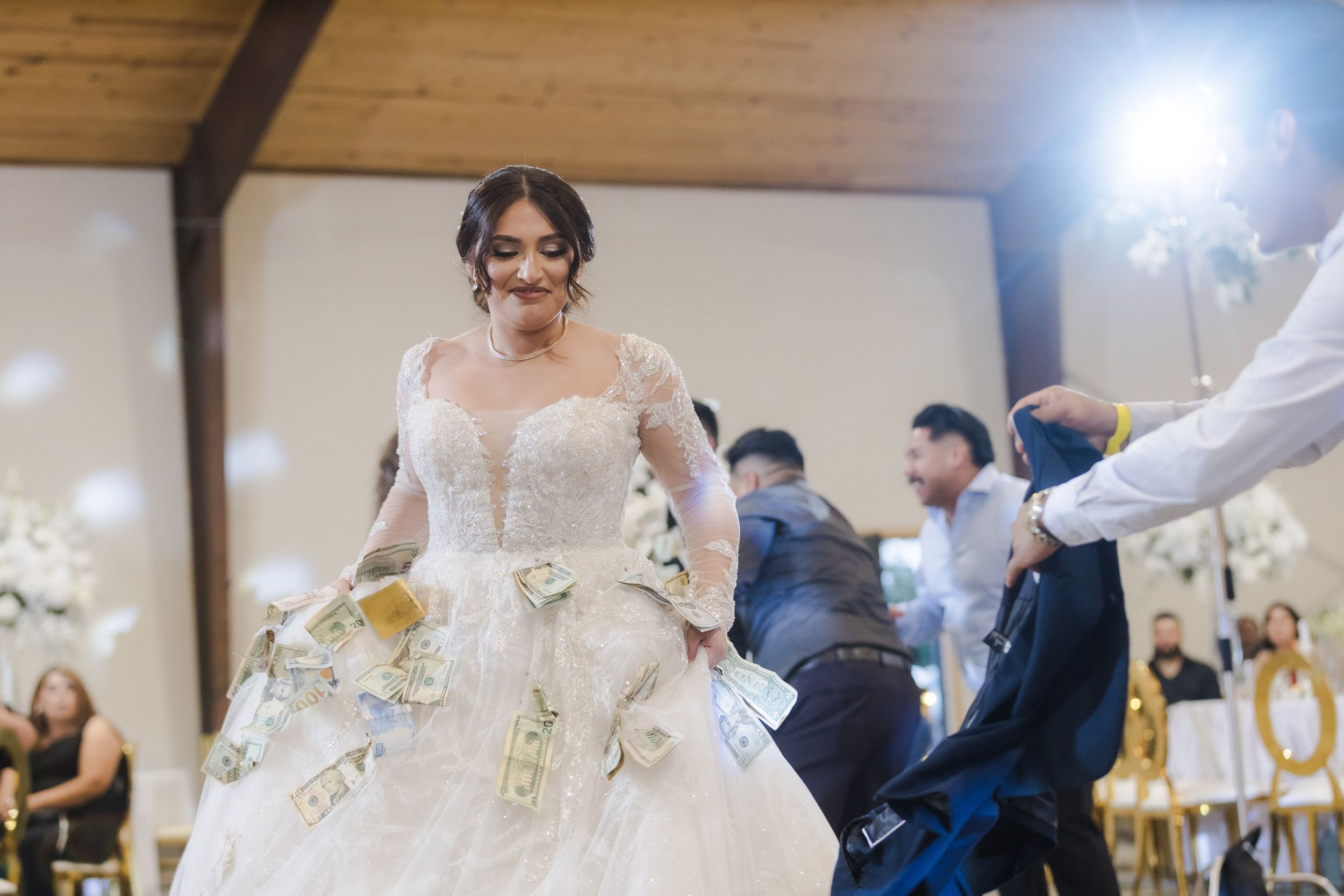 An elegant wedding reception with string lights and rustic wooden beams.