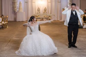 An elegant wedding reception setup with white decor and dramatic lighting in an indoor venue.