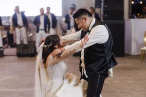 Couple performing a graceful dance move in a beautifully decorated venue.