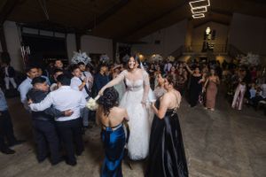 Wedding celebration in a large indoor space with guests dancing and socializing.