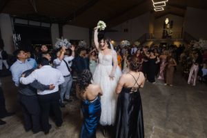 Indoor wedding reception with guests dancing and celebrating on the dance floor.