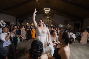 Lively dance party at an indoor wedding reception with decorative lighting.