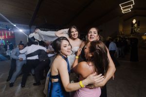Partygoers enjoying an energetic dance celebration at an indoor reception venue.
