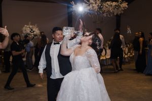 Wedding couple shares intimate dance moment under dim lighting at reception venue.
