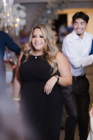 Guest in elegant black dress enjoying the dance floor at wedding celebration.