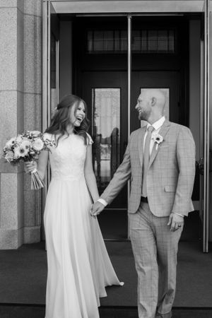 Bride and groom walk out of Rexburg temple on wedding day in Rexburg, Idaho.