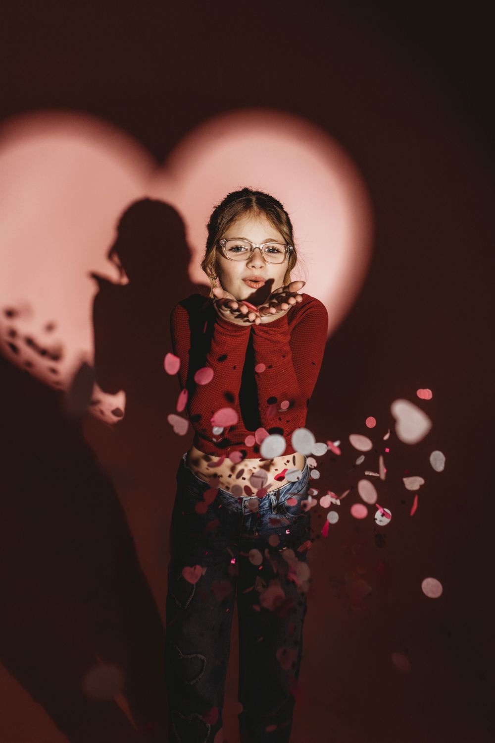 Moody Valentine's portrait with heart-shaped shadows and red clothing.