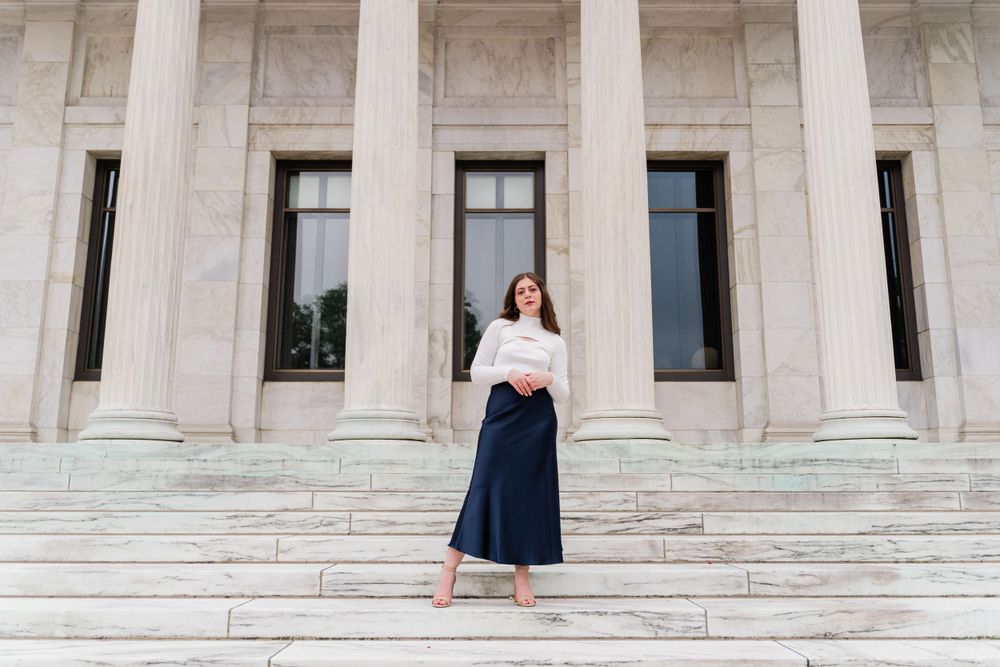 Fashion photo on grand stone steps with white columns featuring a classic navy and white ensemble.