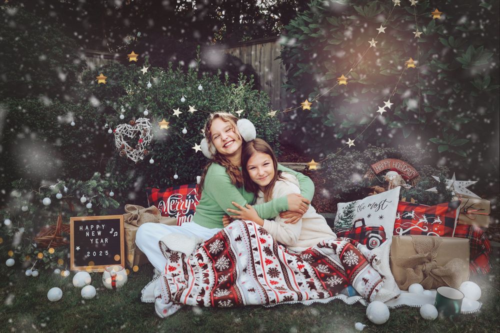 A holiday photo scene with cozy blankets and Christmas decorations against a snowy backdrop.