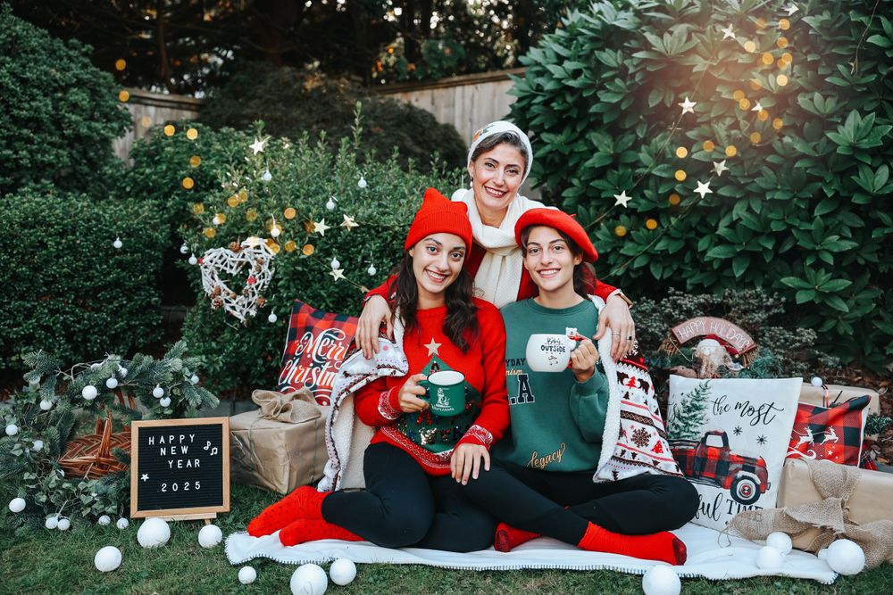 Holiday mini session photo with Christmas decorations and wrapped presents in outdoor garden setting.