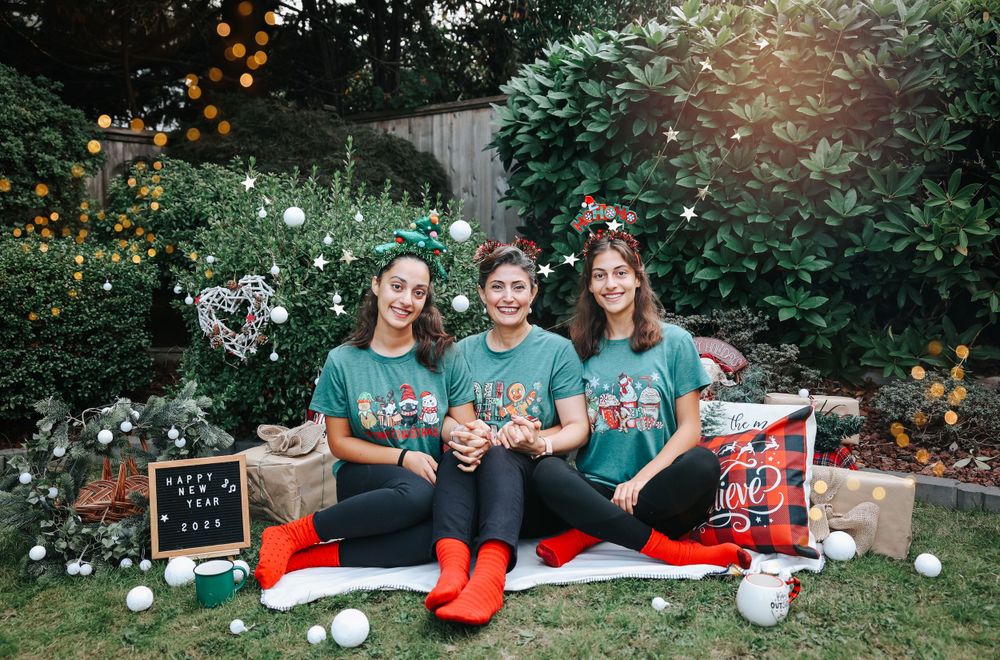 Holiday themed photo session with matching outfits and Christmas decorations in garden setting.