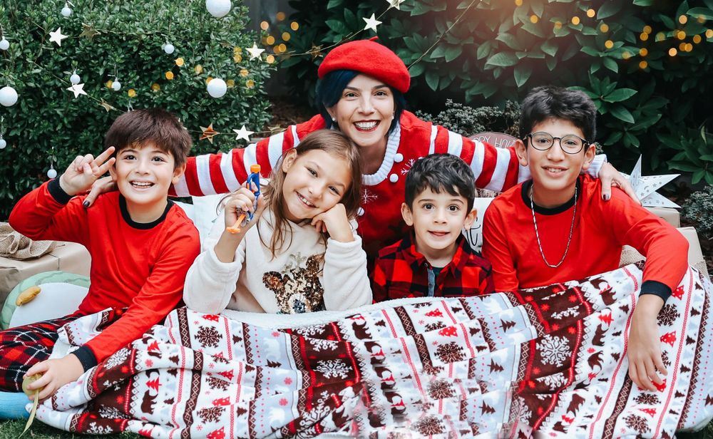 Festive holiday photo with Christmas blankets and decorations in outdoor garden setting.