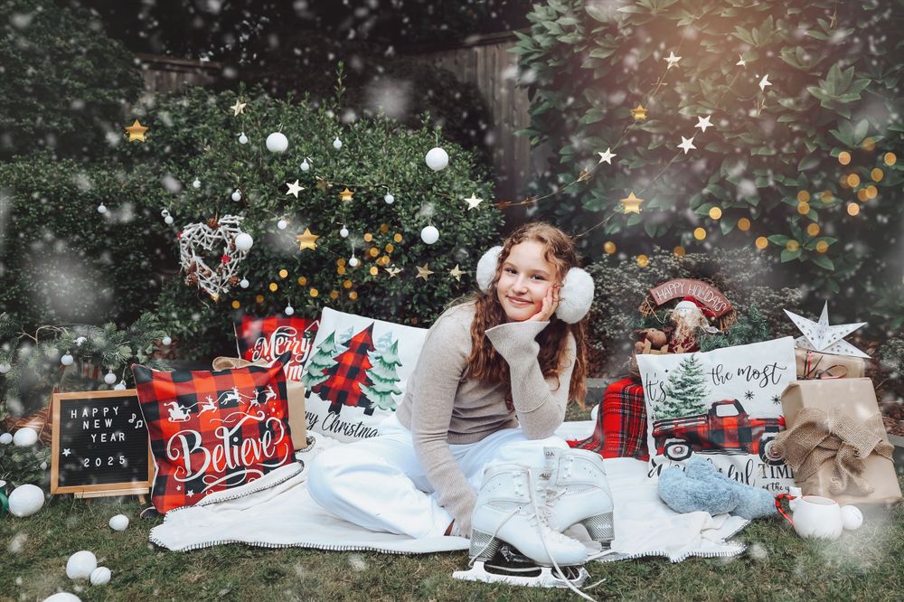 A winter-themed outdoor photo setup with falling snow effect and Christmas decorations.