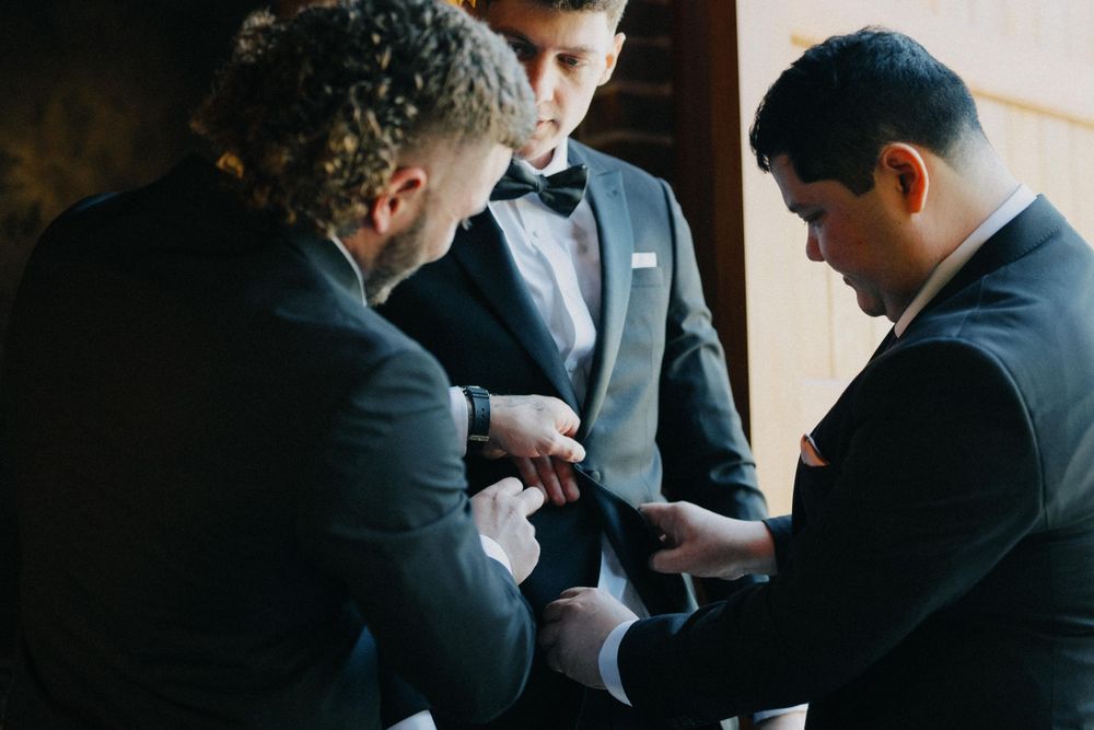 Groom pins boutonnière, Brisbane wedding photographer focuses on small moments