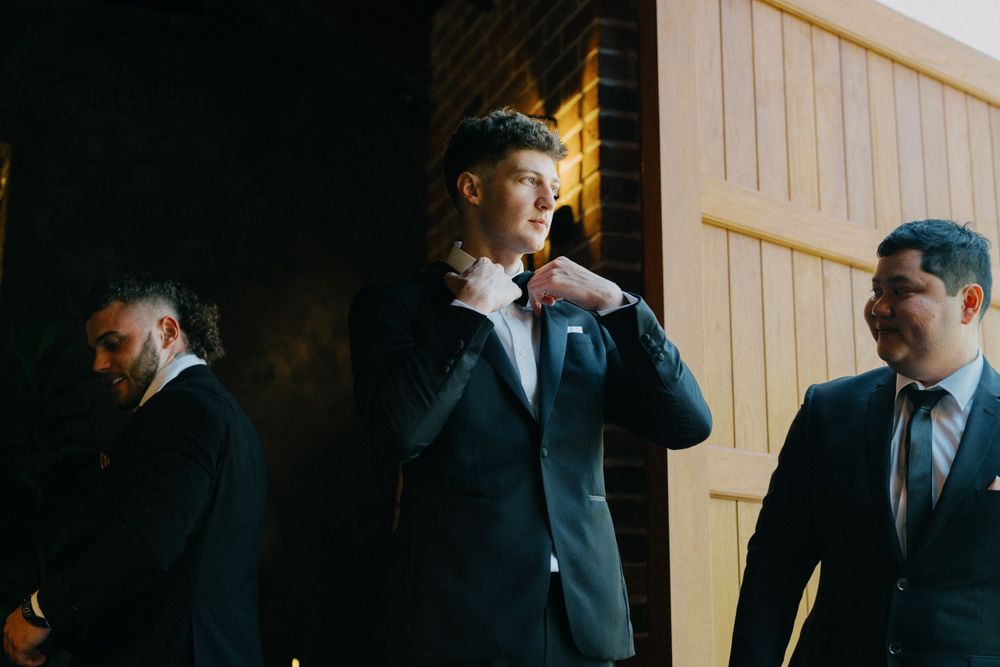 Groom adjusts tie in Valley Estate suite, Brisbane wedding day preparations begin