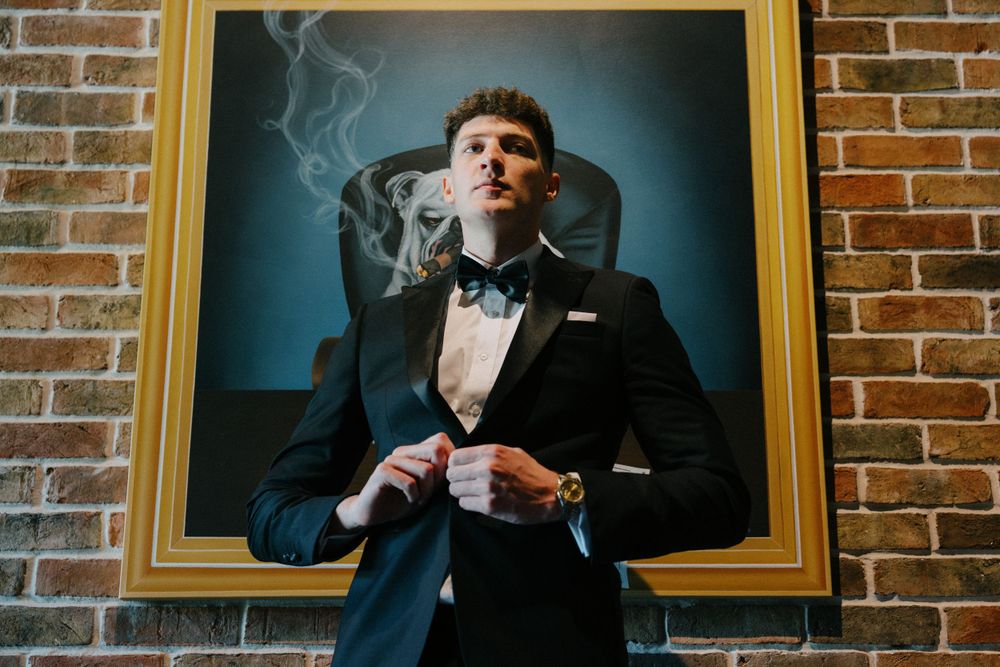 Stylish scene with smoke and formal attire against brick wall backdrop.