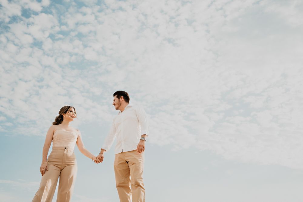 Couple gazing into each other's eyes, with a stunning sky and beach backdrop, capturing their love in Mazatlán