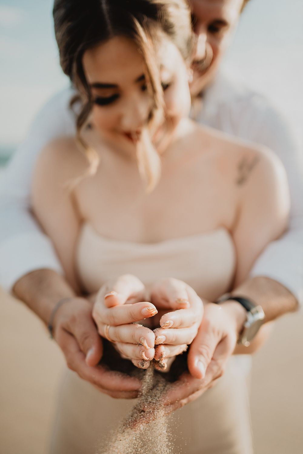 Sharing sand in their hands, symbolizing their unity and connection as they prepare for their future together