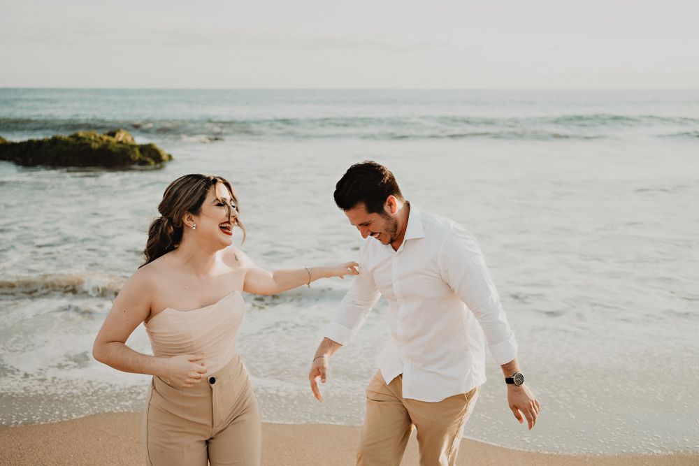 Couple playfully enjoying each other's company, showcasing their fun and loving relationship during their beach session