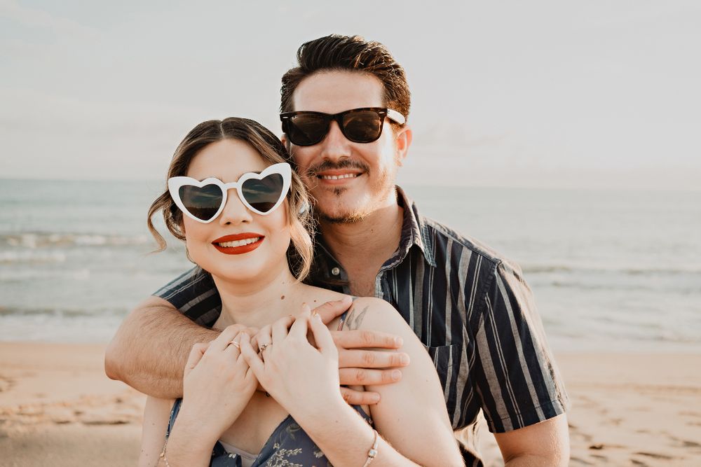 Fun shot of the couple smiling with sunglasses, highlighting their playful personalities in a pre-wedding setting
