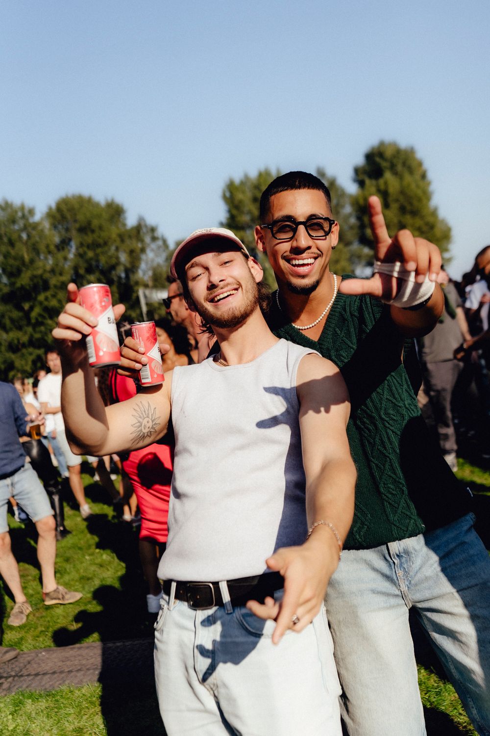 Festival attendees enjoying themselves outdoors while holding beverages on a sunny day.