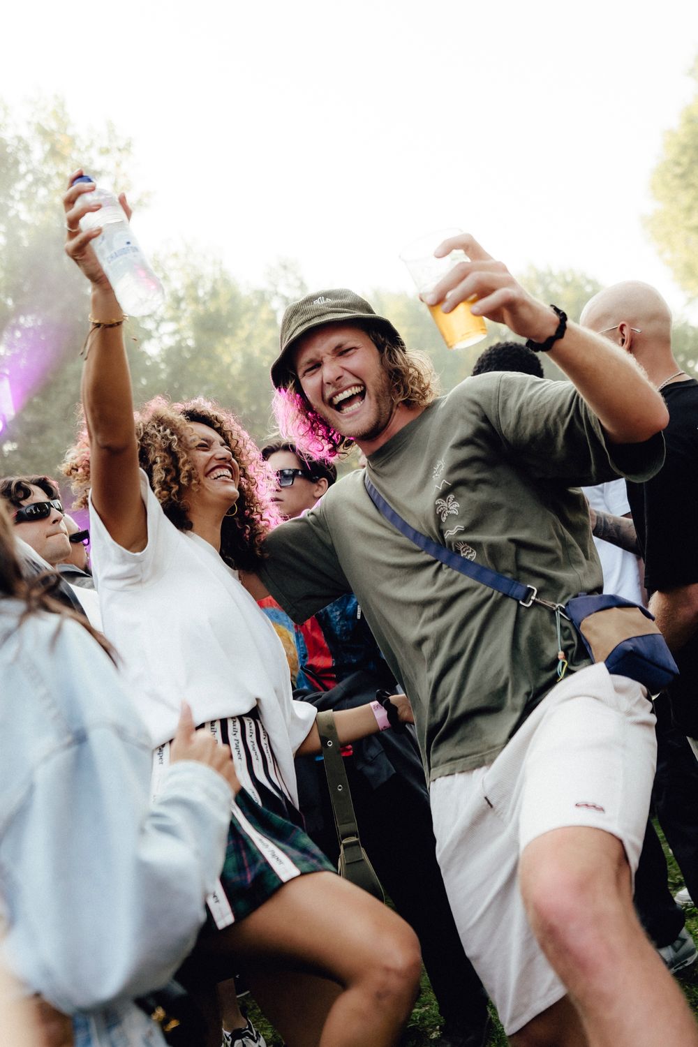 Festival crowd dancing and jumping enthusiastically during outdoor daytime performance.