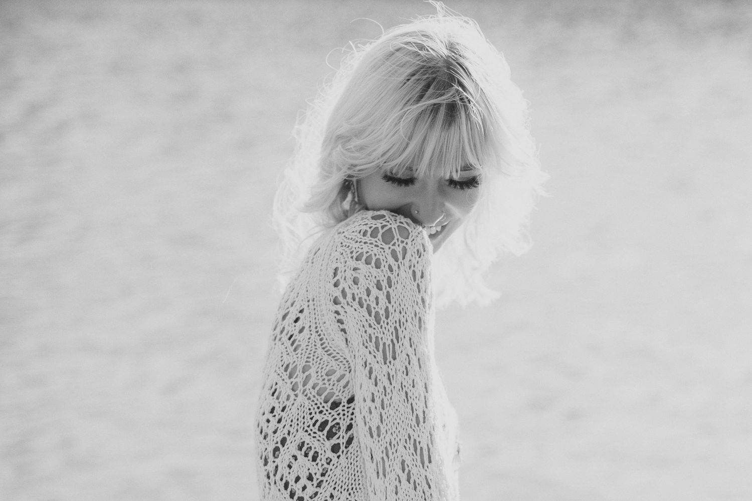 Intimate black and white close-up showing intricate details of a crocheted lace top.