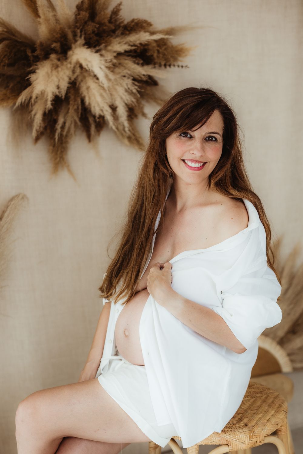 Artistic boudoir photography series featuring white fabric and dried pampas grass decorations against neutral backdrop.