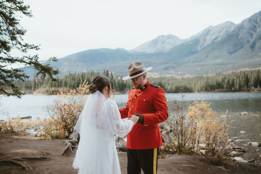 An intimate wedding ceremony moment overlooking a mountain lake with autumn colors.